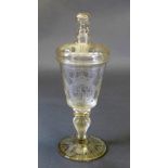 An engraved glass goblet and cover, with armorial crest, the decorated bowl on baluster stem with