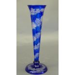 A Bohemian blue glass vase of trumpet form with etched vine and grape decoration on a domed foot.