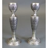 A pair of Isfahan silver candlesticks, the sconce and stepped foot with arabesque design, above an