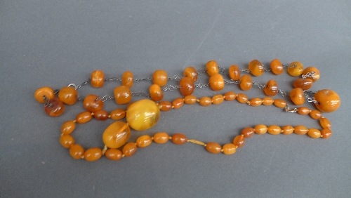 Two strings of semi-translucent butterscotch amber beads, early C20th, one with graduated beads