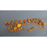 Two strings of semi-translucent butterscotch amber beads, early C20th, one with graduated beads