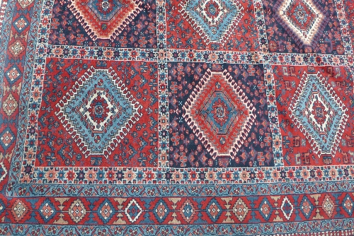 A hand woven Caucasian carpet, the rouge and indigo panelled field with alternating red and blue - Image 2 of 3