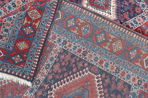 A hand woven Caucasian carpet, the rouge and indigo panelled field with alternating red and blue - Image 3 of 3