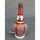 A Bohemian overlaid cranberry glass vase, converted into a table lamp, with repeating geometric