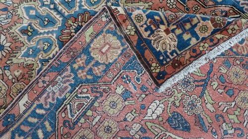 A hand woven Nahavand Persian rug, madder ground with blue floral medallion and border. Width 147 - Image 3 of 3