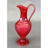 A Victorian cranberry glass claret jug, the faceted elongated neck above globular tapering body with