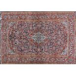 A Kashan rug with an ivory and madder lobed pole medallion enclosed by similar spandrels and