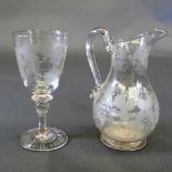 A wine carafe of baluster form with entwined grape and vine etched detail and a matching wine