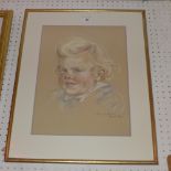 A pastel portrait of a young child signed bottom right, glazed and framed