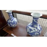 A pair of large Chinese blue and white vases decorated with intertwining dragons