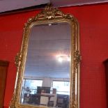 A French style pier mirror with arched bevelled plate within ornate gilt frame with rose surmount
