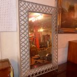 A wrought iron lattice form mirror with rectangular mirror plate