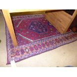 A hand knotted Persian rug the red fields with central pendant and all over geometric decoration