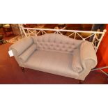 A double scroll arm settee upholstered in buttoned grey linen fabric with bolster cushion and