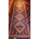 A Persian design runner with central pendant medallions to the blue ground and geometric motifs in