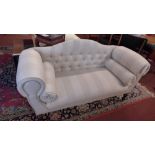 A contemporary double scroll arm settee upholstered in buttoned beige fabric raised on turned