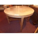 An Arts and Crafts oak dining table the circular top raised on stretchered square section supports