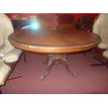 A Victorian walnut and ebonised loo table the oval top raised on carved quadruped supports