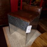 An aluminium clad Aviator style stool upholstered in tan leather of cube form