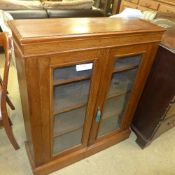 A Victorian walnut bookcase fitted with glazed panel doors enclosing shelves on plinth base