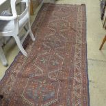 A hand knotted Persian runner with brick field and central medallion motifs