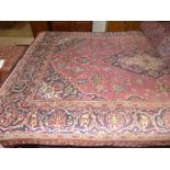 A Kashan rug, the cerise ground with indigo and ivory lobed pole medallion enclosed by similar