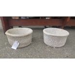 A pair of reconstituted stone planters in the form of baskets