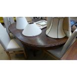A mahogany extending oval dining table with extra leaf