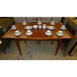 A teak extending dining table with four matching stick back chairs