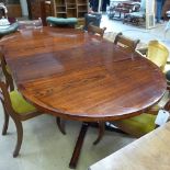 A mid-twentieth century Danish rosewood dining table extending to take two extra leaves and raised