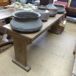 An Arts and Craft oak serving table, the plank top raised upon shaped sides