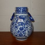 A blue and white Oriental vase decorated with dragons and deer head handles