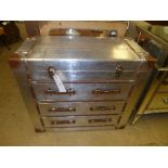 A polished metal aviator chest with hinged lid over three drawers