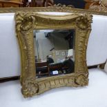 A C19th looking glass with bevelled plate within ornate gilt frame