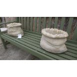 A pair of reconstituted stone planters in the form of sacks