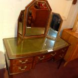 A bow front mahogany desk with a green l