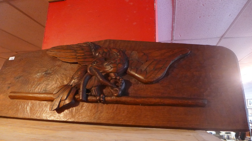 A carved oak panel with image of an eagl