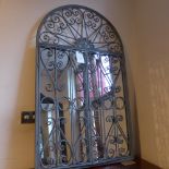 A wrought metal garden mirror with arche