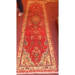 A Persian hand knotted Hamadan runner the rouge field having repeating garden and flower head motifs