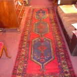 A hand knotted Persian Hamadan runner the red field having blue medallion and geometric motifs in