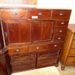 An Indian teak cabinet with selection of drawers and panel doors raised on plinth base