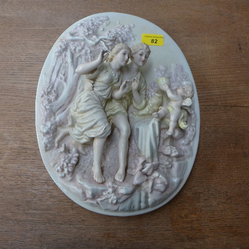 A pair of Meissen style wall plaques with cherub decoration