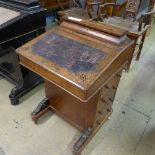 An inlaid walnut Davenport with hinged top over side drawers on castors