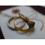 An 18ct gold sapphire and diamond ring and a 22ct gold wedding band and one other
