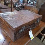 A brown crocodile skin suitcase