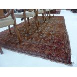 A fine old north east Persian Turkoman carpet 318 cm x 168 cm repeating gul motifs on terracotta