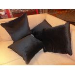 A set of four cushions upholstered in black velour