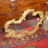 A Continental cartouche form mirror in ornate gilt glass frame