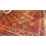 A hand knotted Heriz carpet the red and blue fields with repeating geometric motifs within a bold