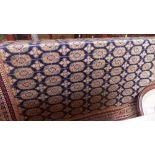 A Bokhara design carpet the blue fields with repeating elephant foot motifs within a geometric